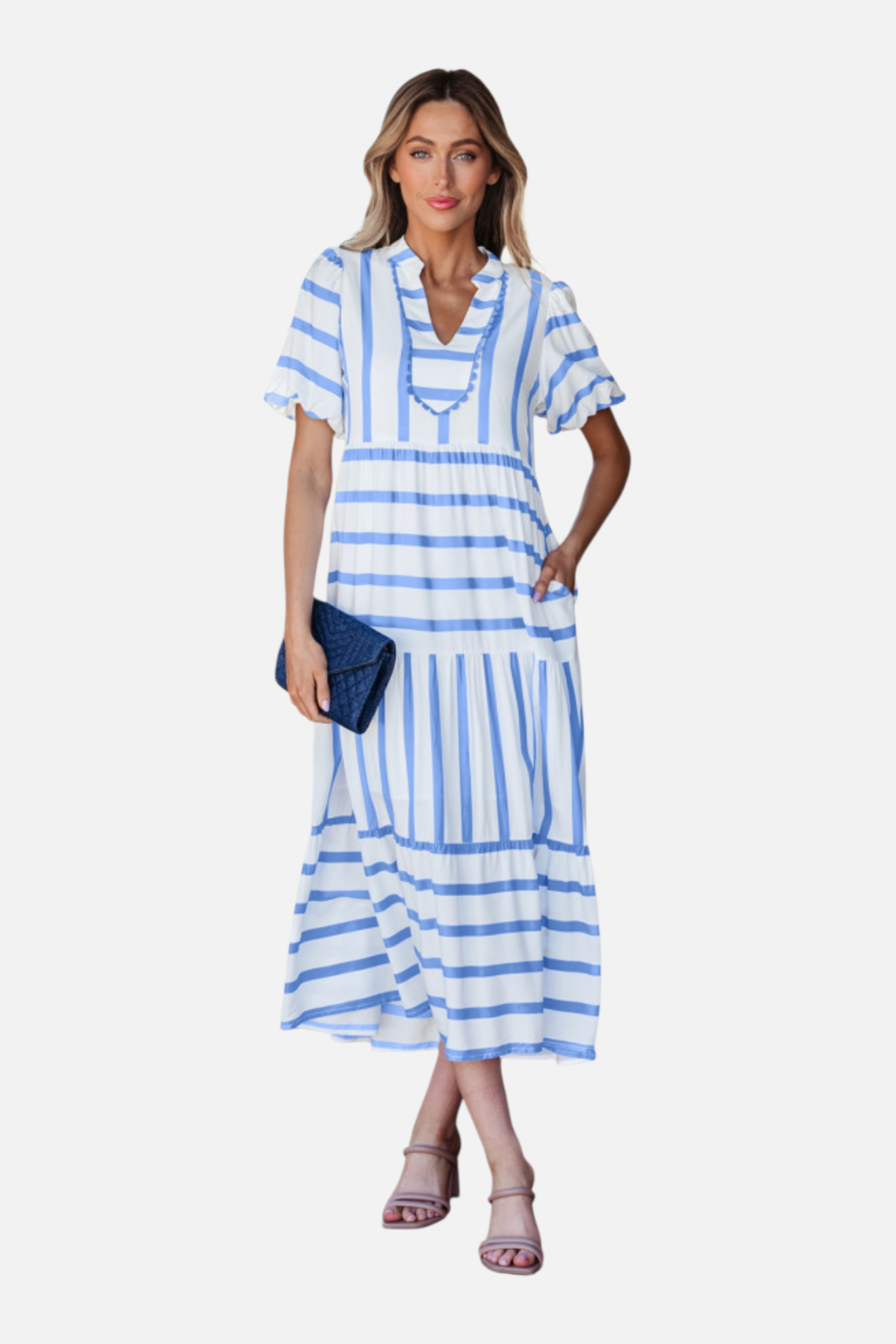 A model showcasing the sky blue striped midi dress, featuring a notched V-neckline with blue ricrac trim, puff sleeves, and a tiered skirt in a vacation-ready 100% viscose fabric.