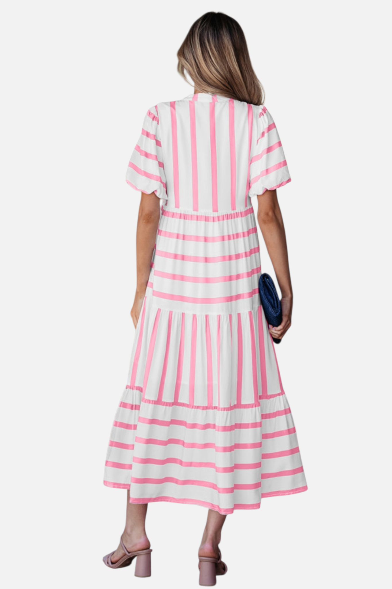 Rear view of a model showcasing the pink striped midi dress, featuring a notched V-neckline with pink ricrac trim, puff sleeves, and a tiered skirt in a vacation-ready 100% viscose fabric.