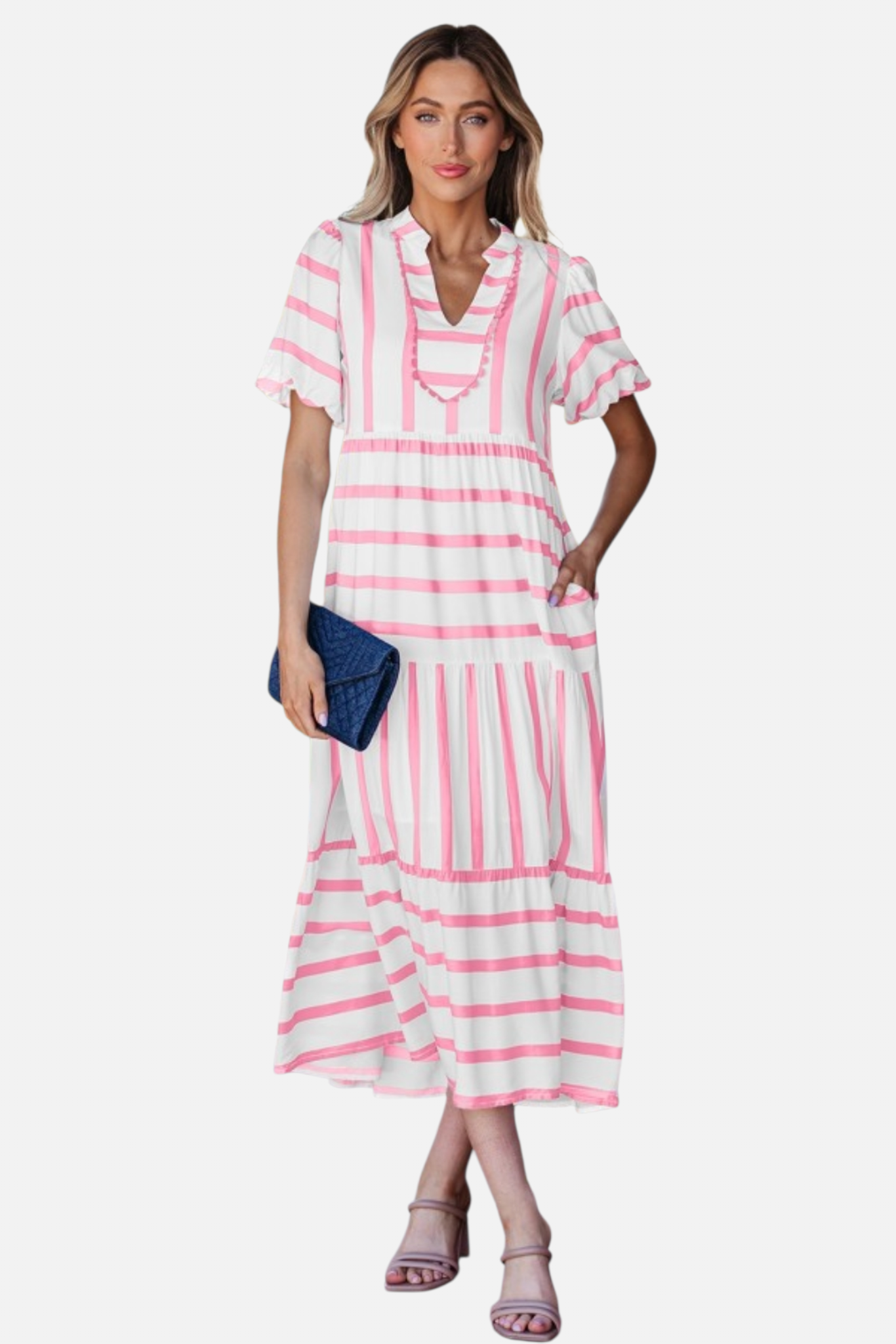 A model showcasing the pink striped midi dress, featuring a notched V-neckline with pink ricrac trim, puff sleeves, and a tiered skirt in a vacation-ready 100% viscose fabric.