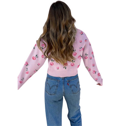 Person wearing a pink floral sweater and blue jeans on a white background