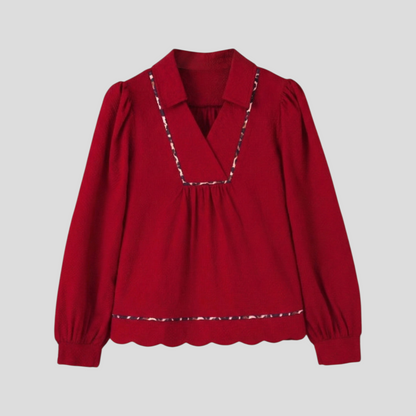 Front flat lay of a long-sleeved red textured blouse featuring a collared V-neckline and subtle leopard print trim detailing.
