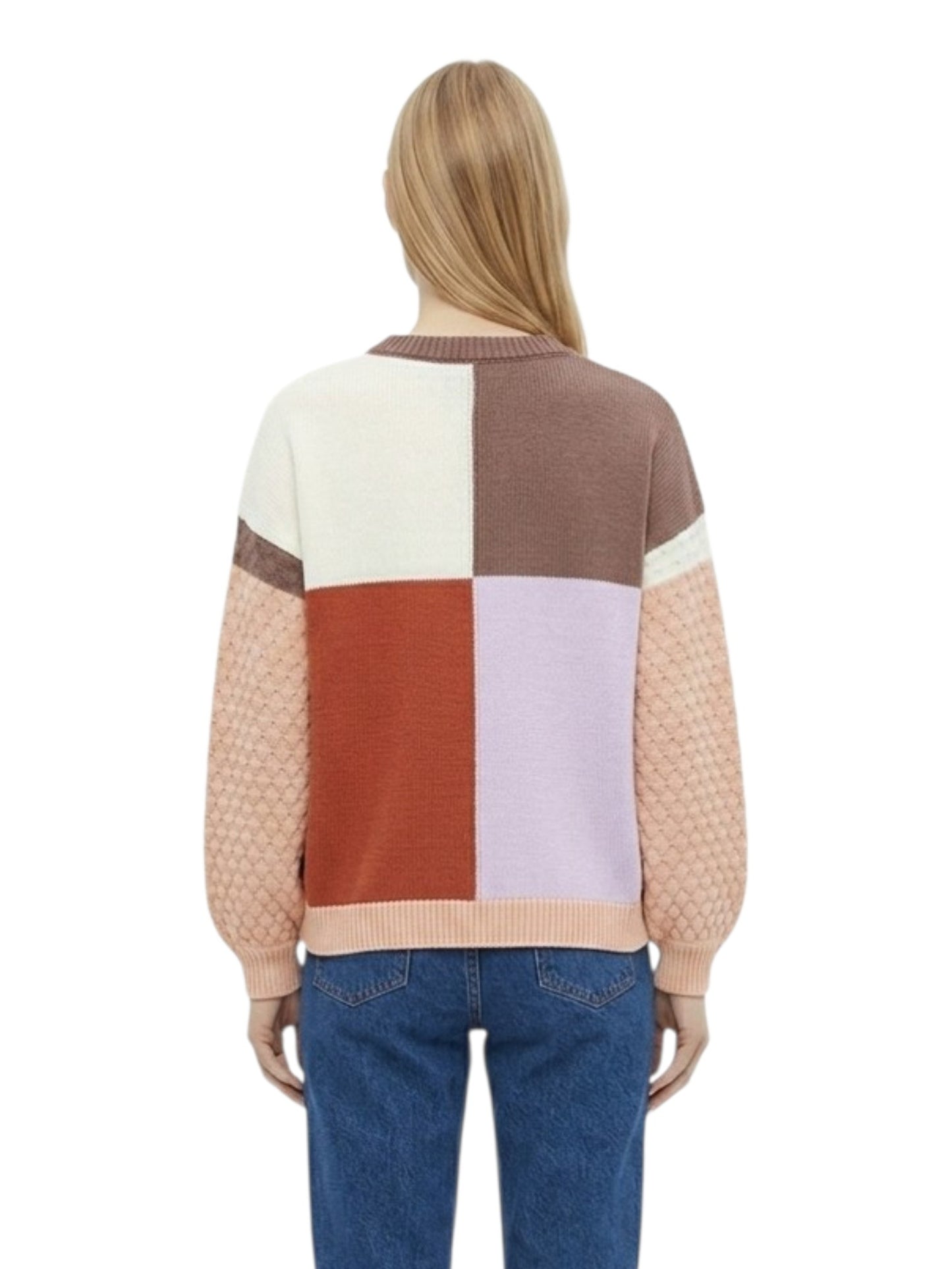 A woman viewed from the back wearing a color-block knit sweater with cream, brown, rust, pale lavender, and peach panels, paired with blue jeans and white sneakers on a white background - three-quarter length view.