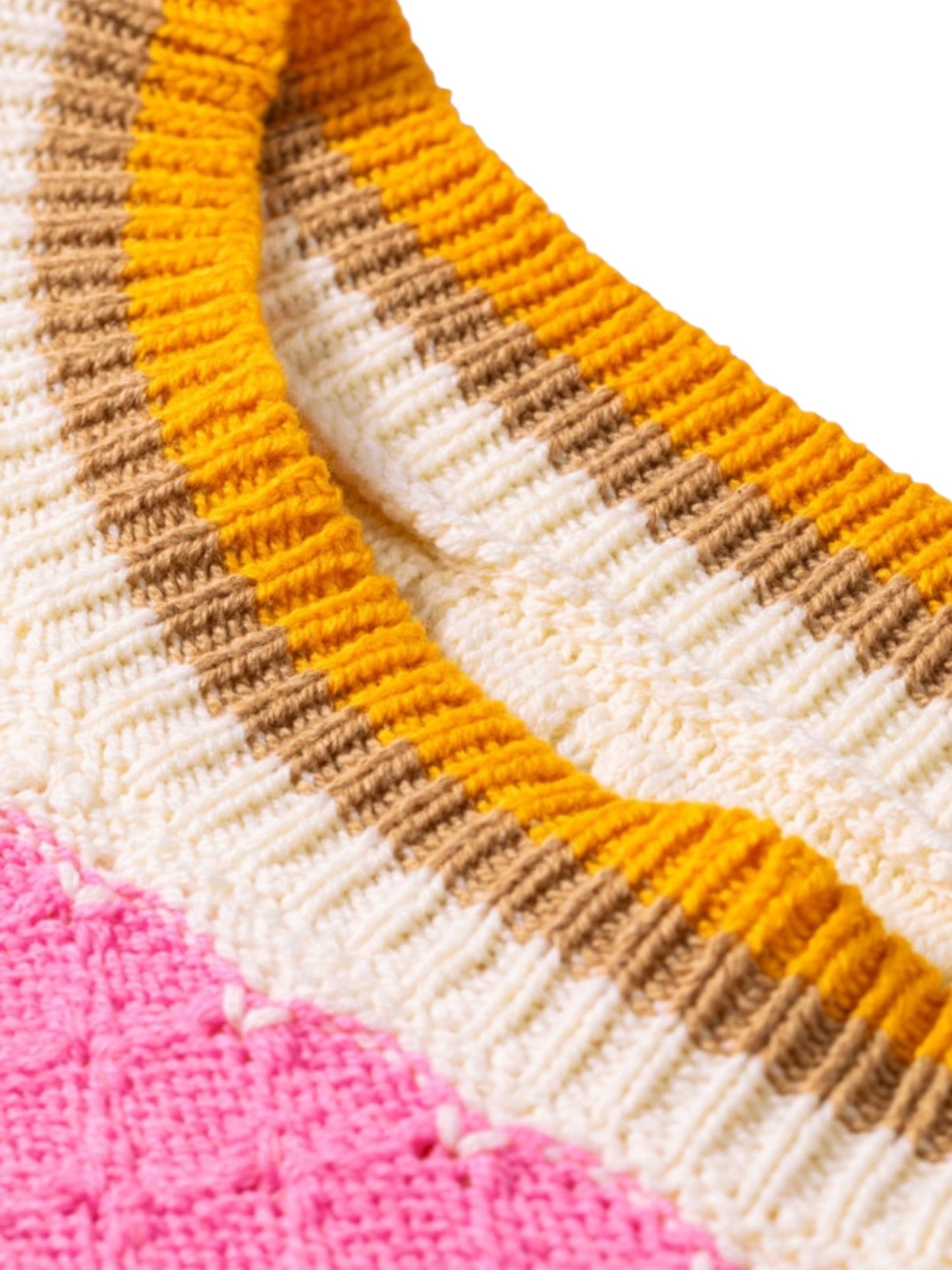 Close-up of a knitted garment showing a curved neckline with horizontal stripes in yellow, brown, and cream, with a pink textured section visible in the lower left corner.