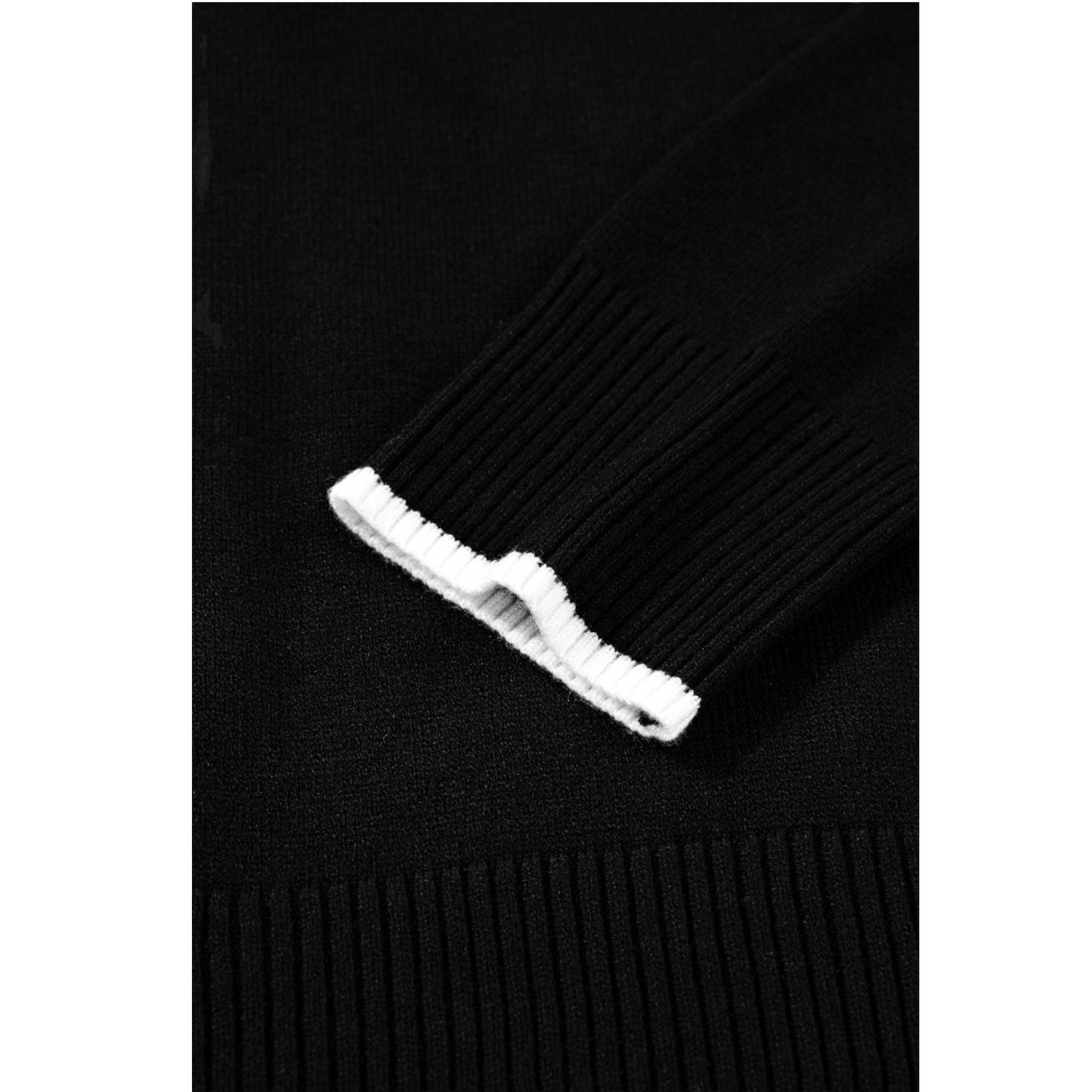 Close-up of a black sweater with a white button on a white background