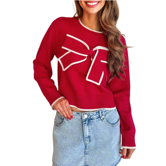 Red sweater with a large white bow design worn by a person on a white background