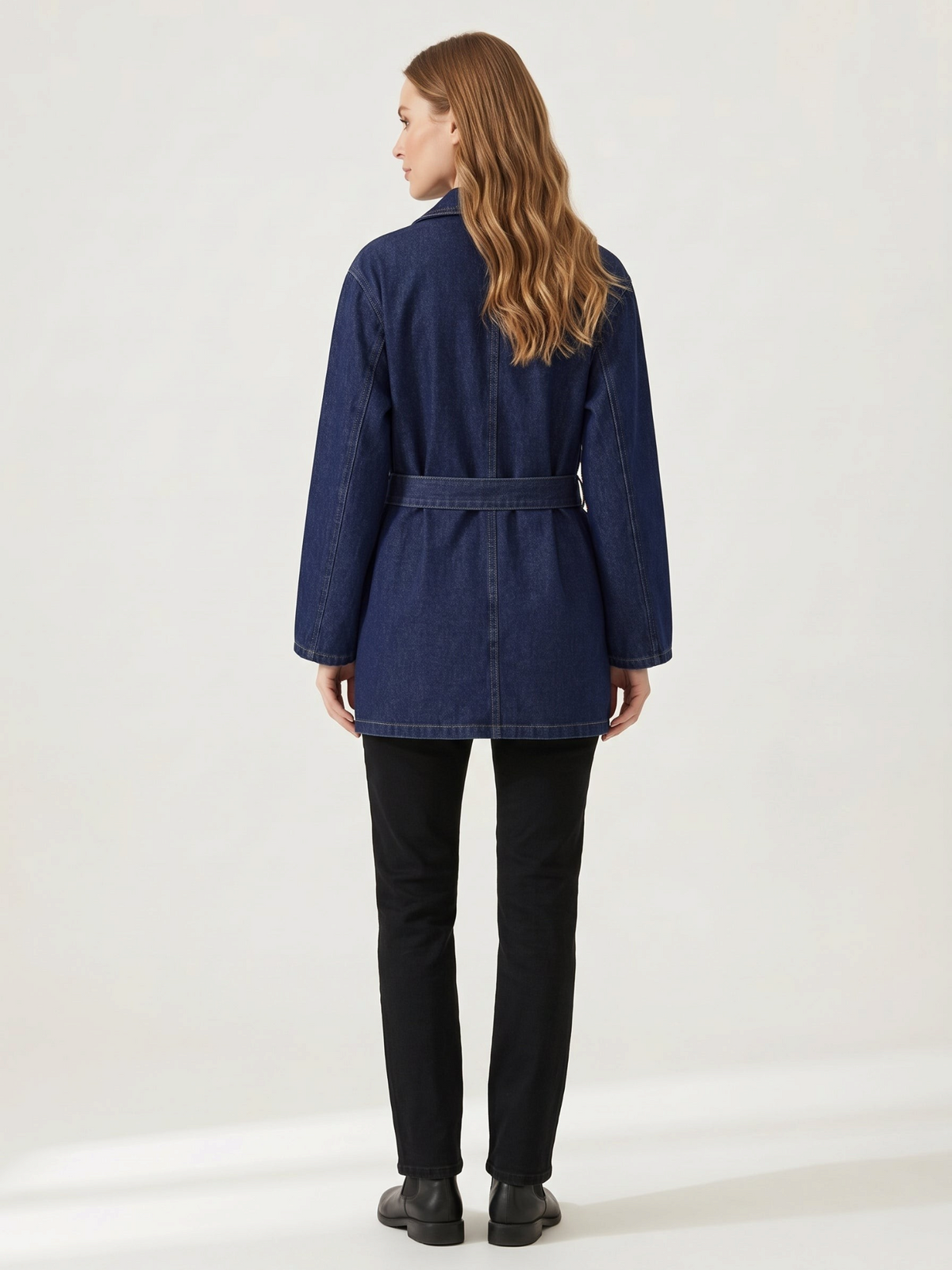 Catherine Martin mid-length dark blue denim coat with a waist tie, worn by a woman from the back view.