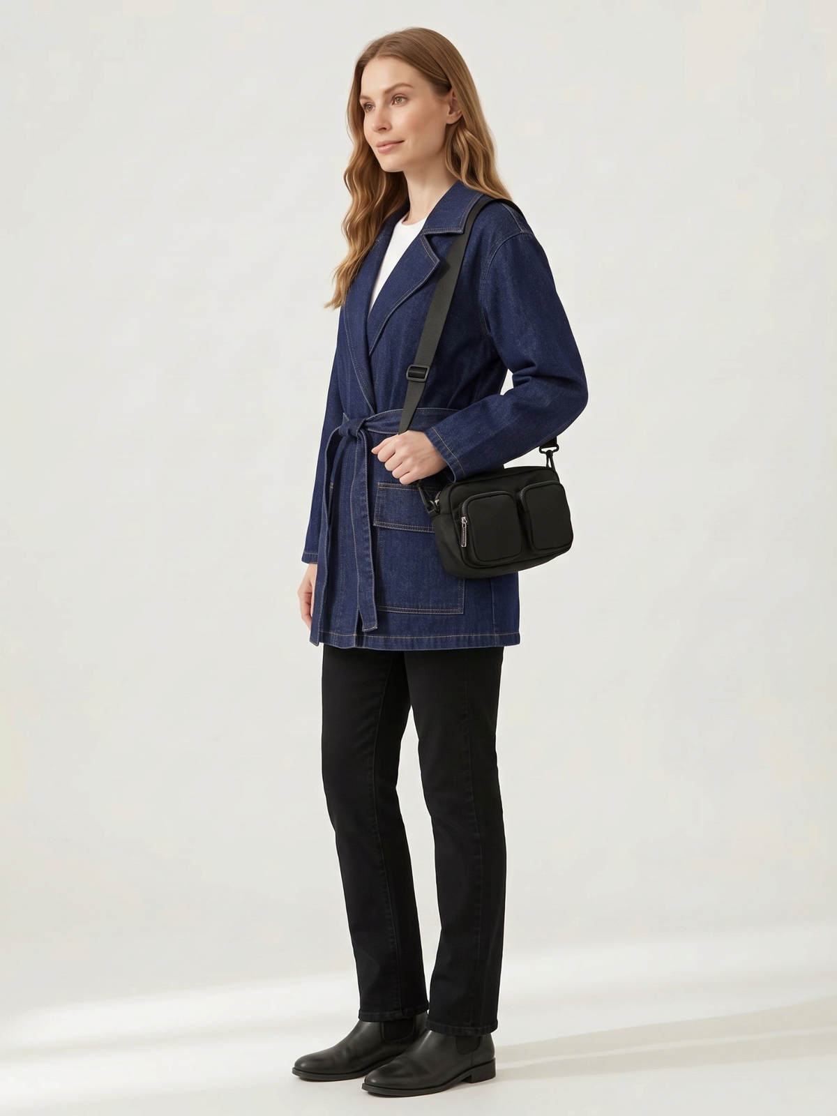 Catherine Martin denim-polyester coat with a waist tie and front pockets worn by a woman with a black crossbody bag