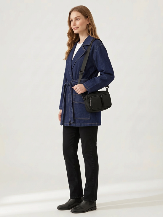 Catherine Martin denim-polyester coat with a waist tie and front pockets worn by a woman with a black crossbody bag
