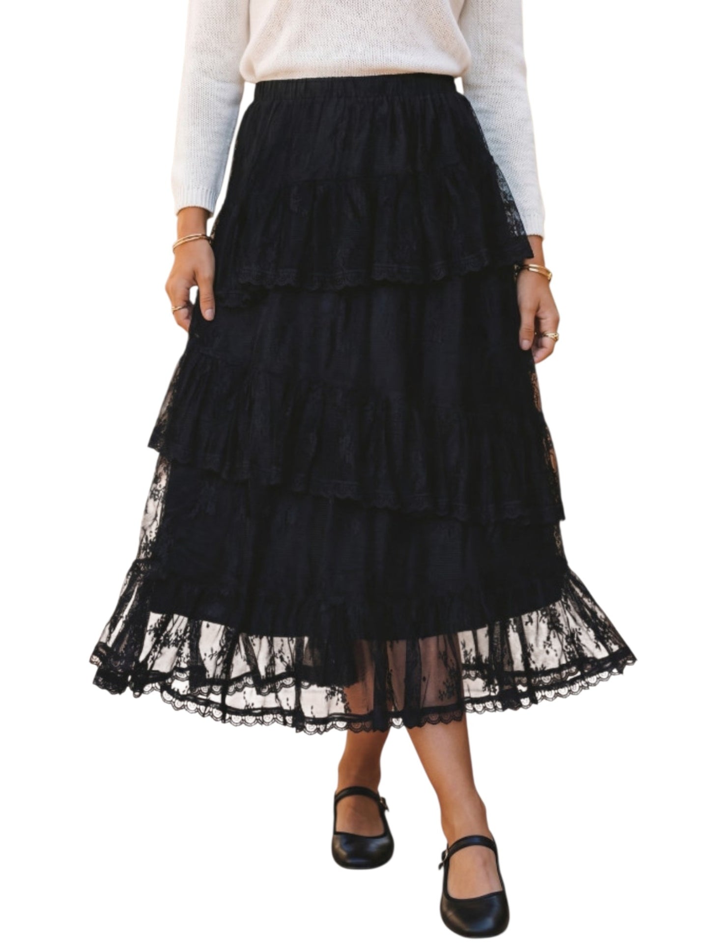 A black tiered ruffle midi skirt with sheer lace trim, shown on a model wearing a white long-sleeve top and black Mary Jane shoes against a white background.