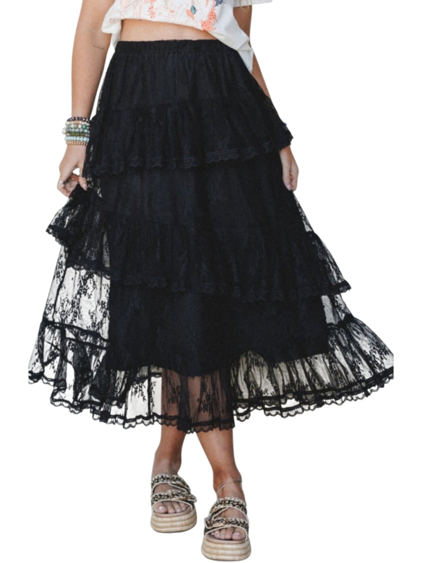 A black tiered lace maxi skirt worn by a model, paired with a white floral crop top and espadrille platform sandals, shown against a plain white background.