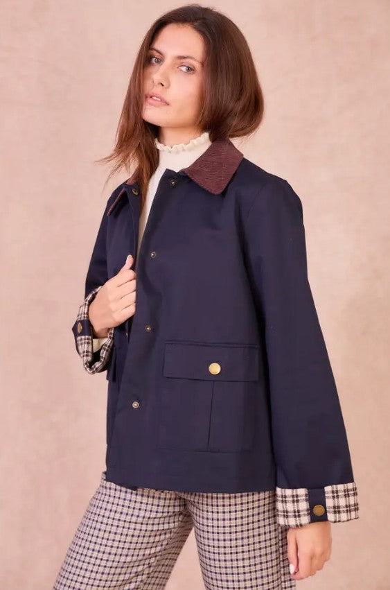 Front view of a model wearing the navy Valerie cotton jacket with a burgundy corduroy collar and checkered cuffs.