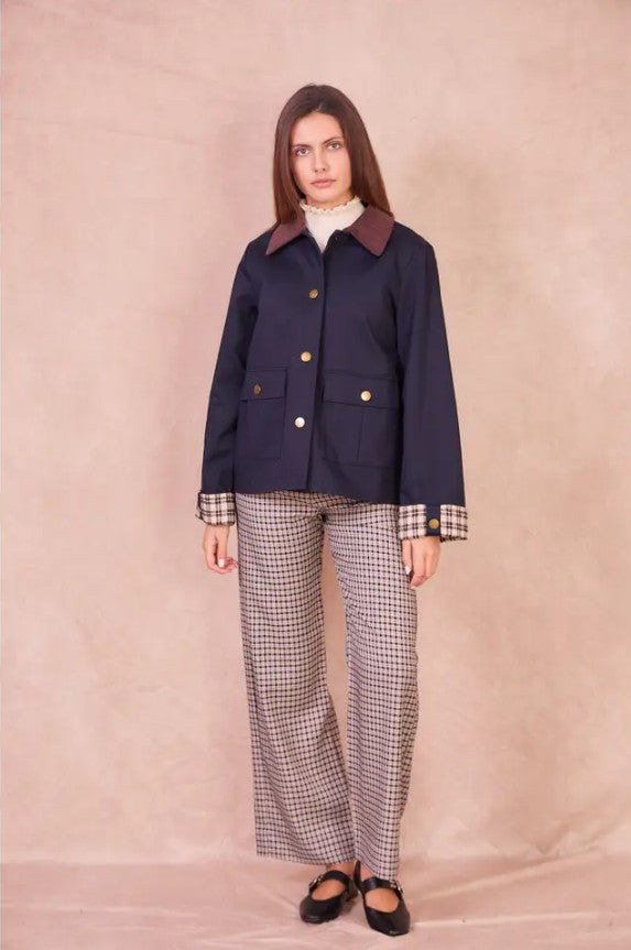 Front view of a model wearing the navy Valerie cotton jacket with a burgundy corduroy collar and checkered cuffs.