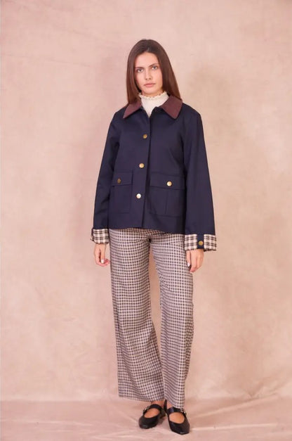 Front view of a model wearing the navy Valerie cotton jacket with a burgundy corduroy collar and checkered cuffs.