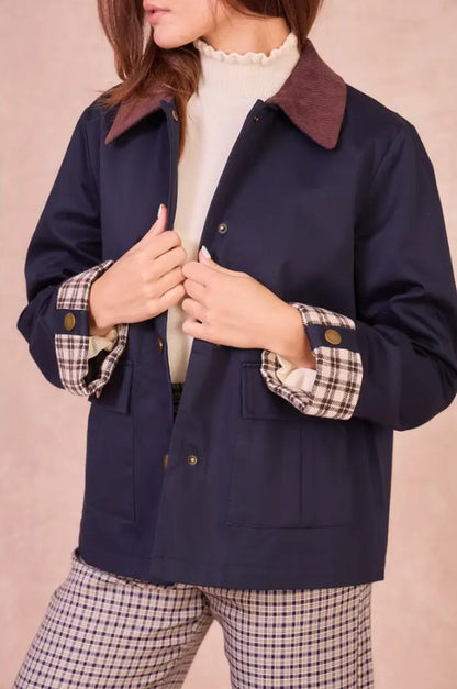 Close-up of the navy Valerie jacket highlighting the gold snap buttons and plaid-lined turned-up cuffs.
