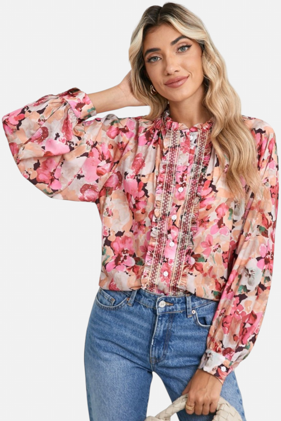Woman wearing a floral blouse and jeans on a white background