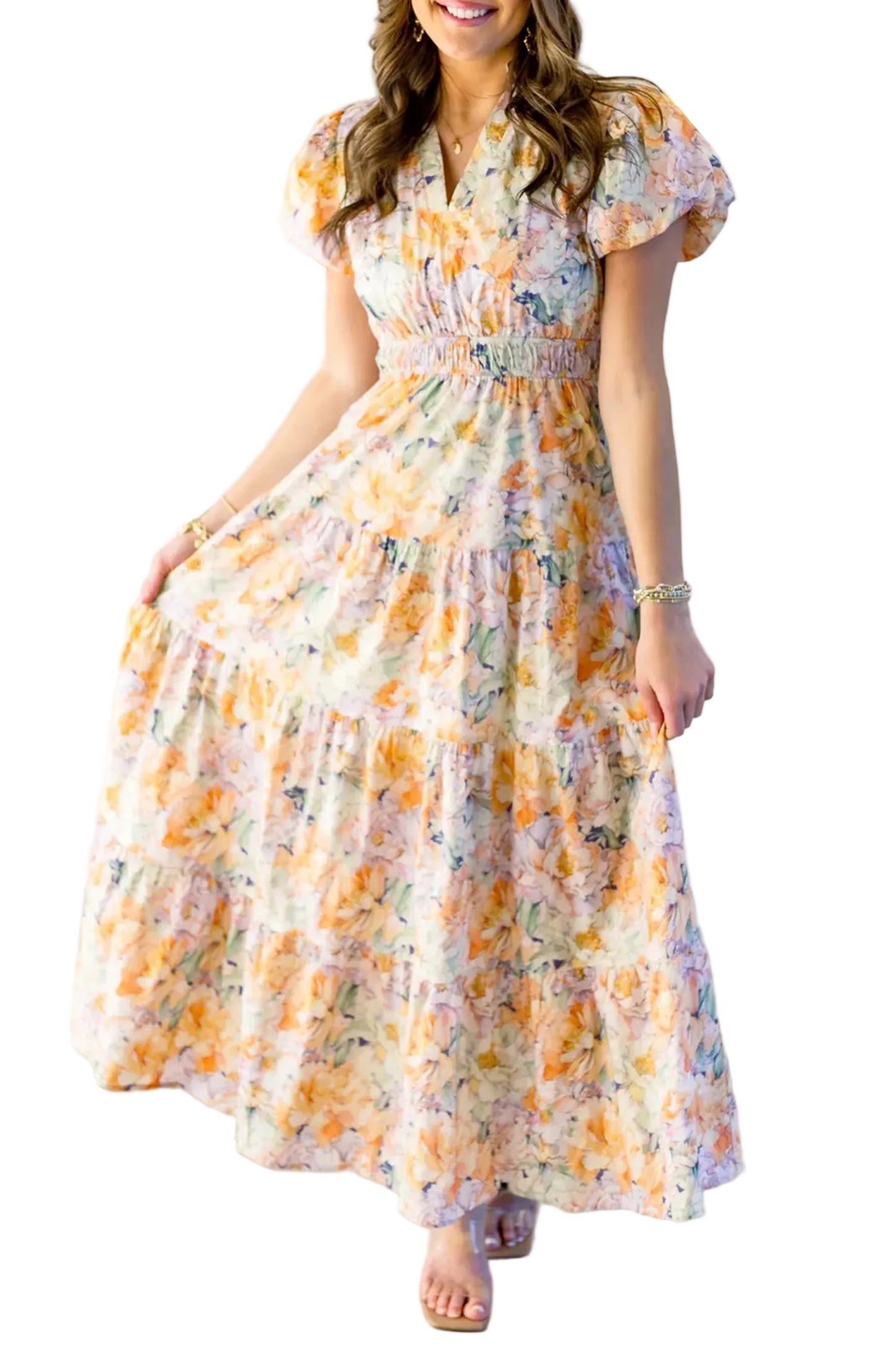 Front studio view of a model in a high-waisted tiered maxi dress holding out the apricot watercolor floral printed skirt.
