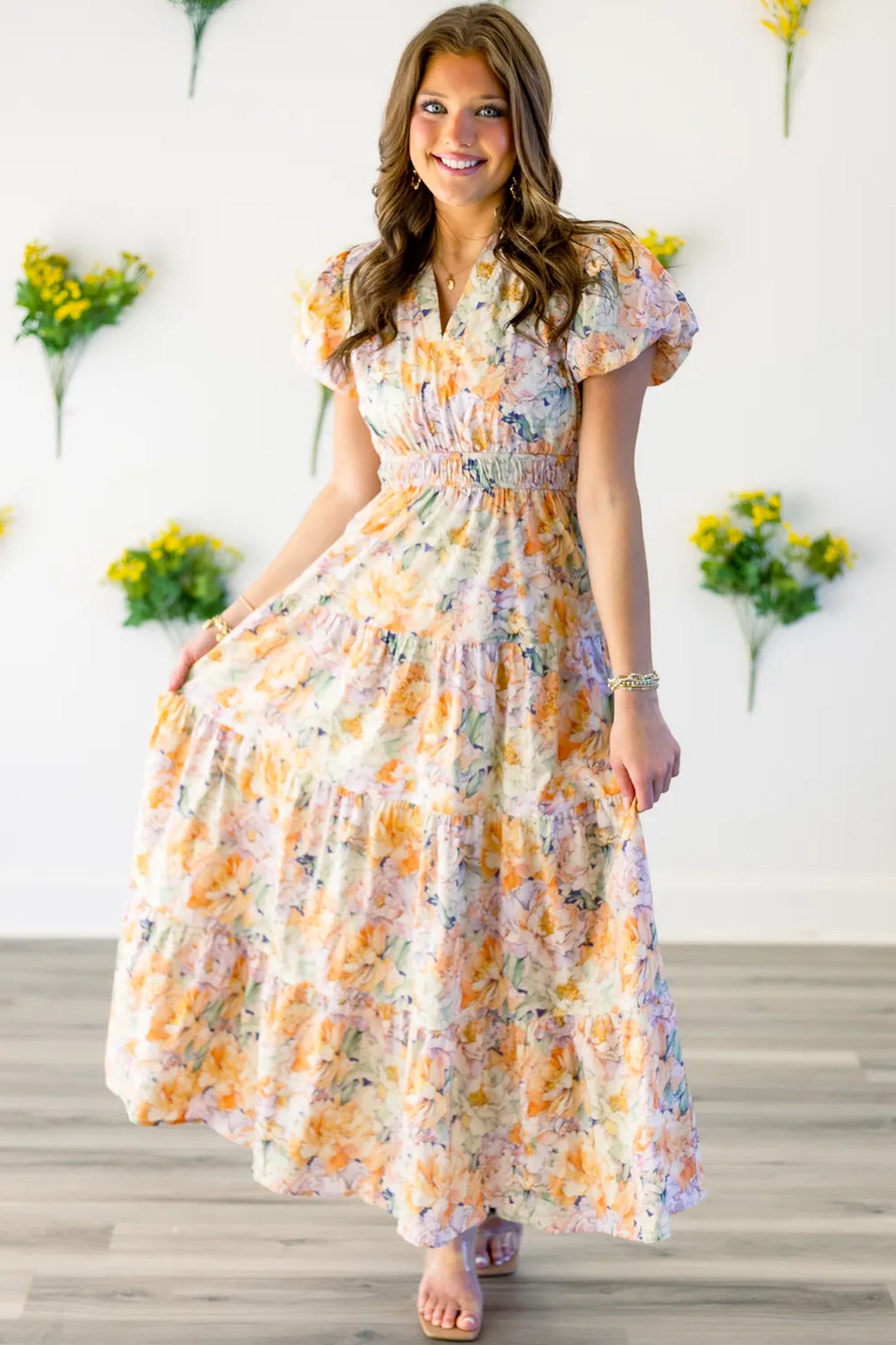 Woman wearing a floral dress with a white background and decorative flowers.