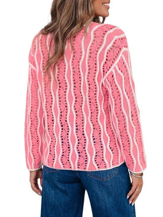 A woman shown from the back wearing a pink knit cardigan with vertical white wavy stripes and blue jeans, against a plain white background.