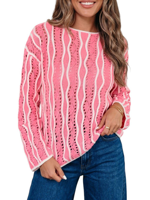 A woman wearing a pink and white wavy knit sweater with blue jeans, shown from the waist up against a plain white background.