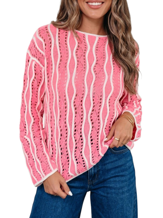A woman wearing a pink and white wavy knit sweater with blue jeans, shown from the waist up against a plain white background.