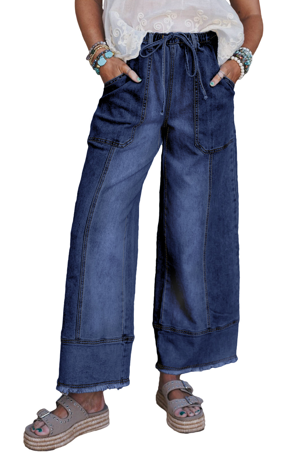 Blue wide-leg jeans worn by a person on a white background
