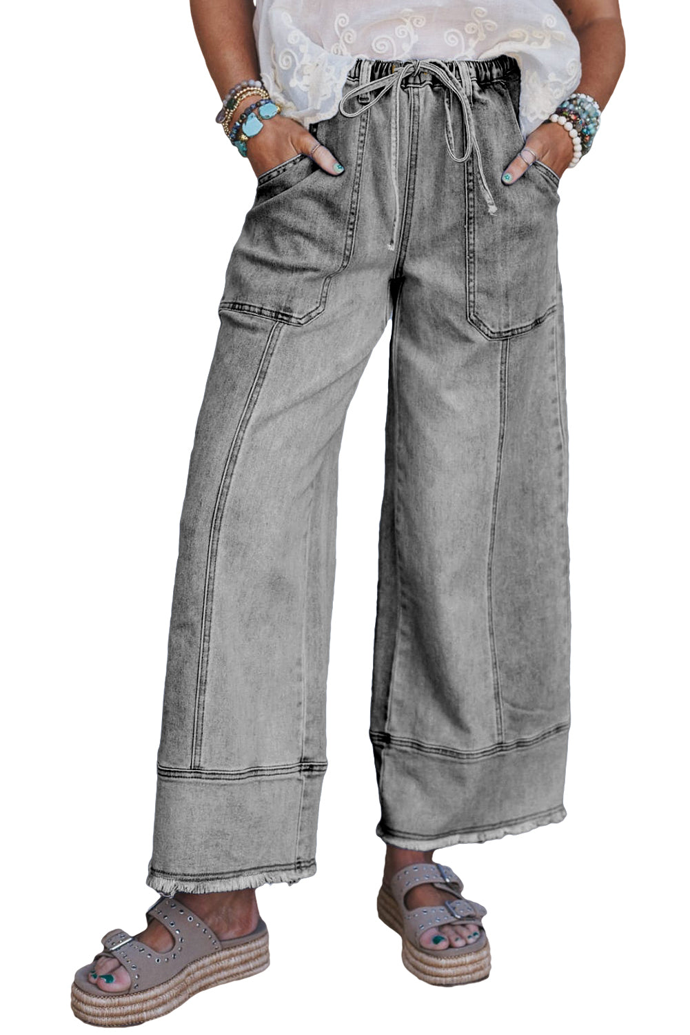 Person wearing wide-leg gray jeans on a white background