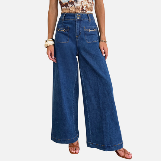 A model wearing high-waisted, wide-leg denim trousers featuring metallic hardware accents and functional patch pockets, styled for a modern street-style look.