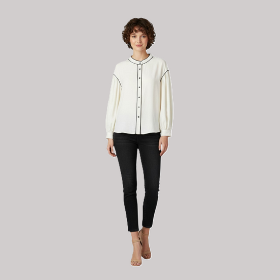 A model wearing the Contrast Trim Bishop Sleeve Blouse tucked into black skinny jeans with nude heels, showcasing a sophisticated smart-casual silhouette.