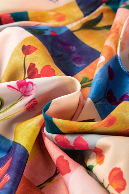 A multicolour floral check blouse with short sleeves on a hanger. Fabric view.