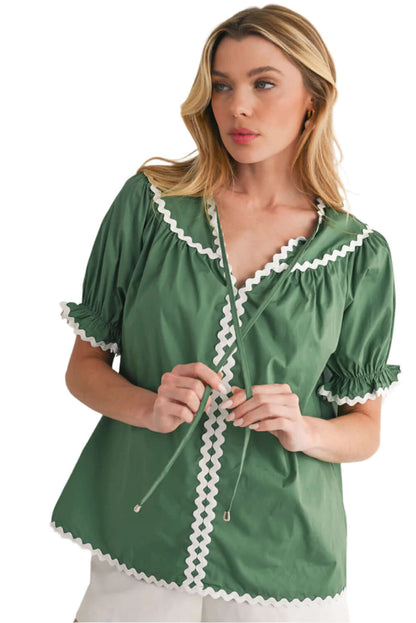 Model wearing Mist Green blouse with puff sleeves and feminine ricrac detailing.