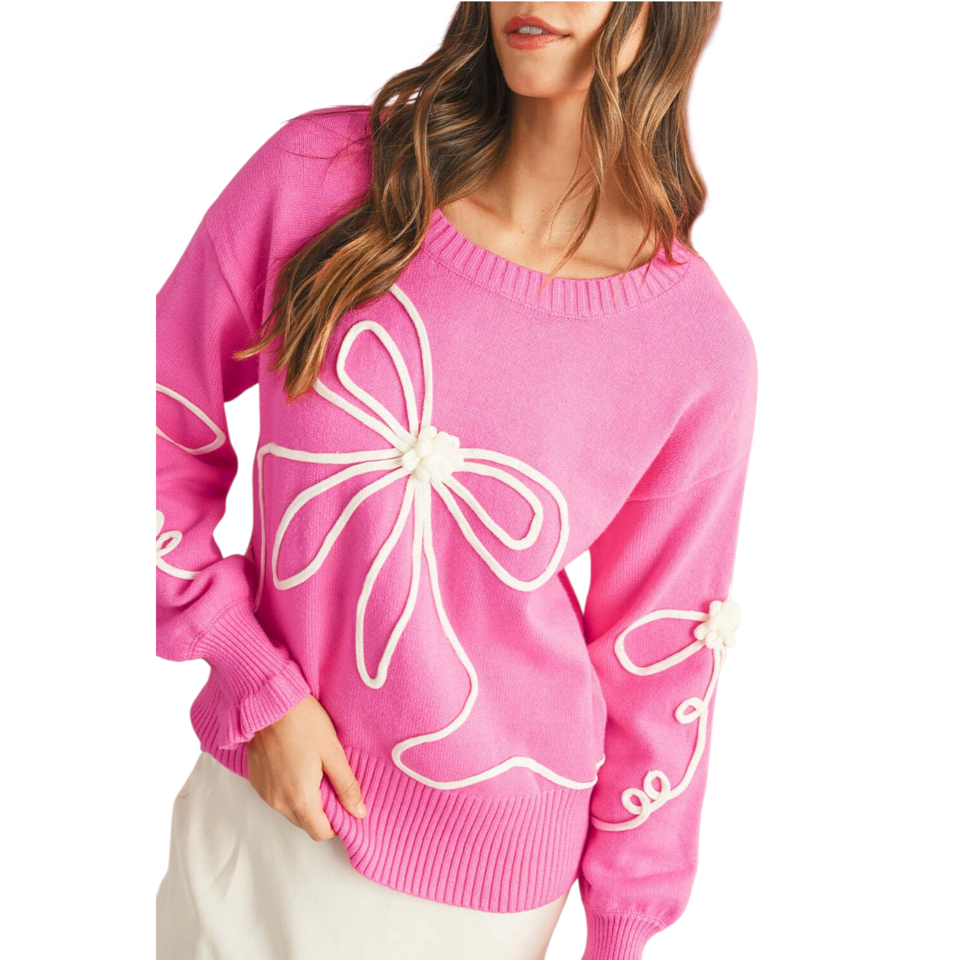 Pink sweater with white floral designs worn by a person