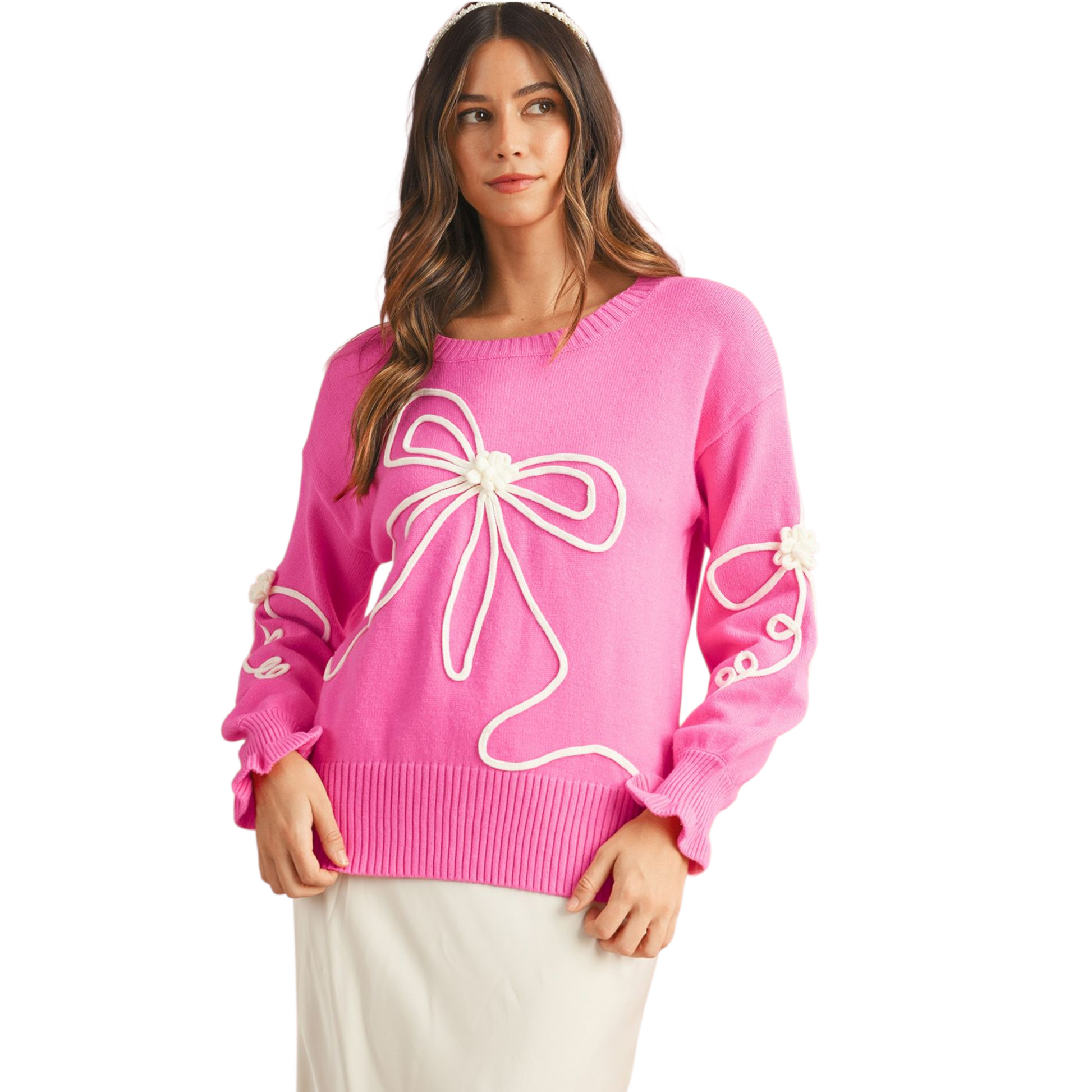 Woman wearing a pink sweater with white bow designs on a white background