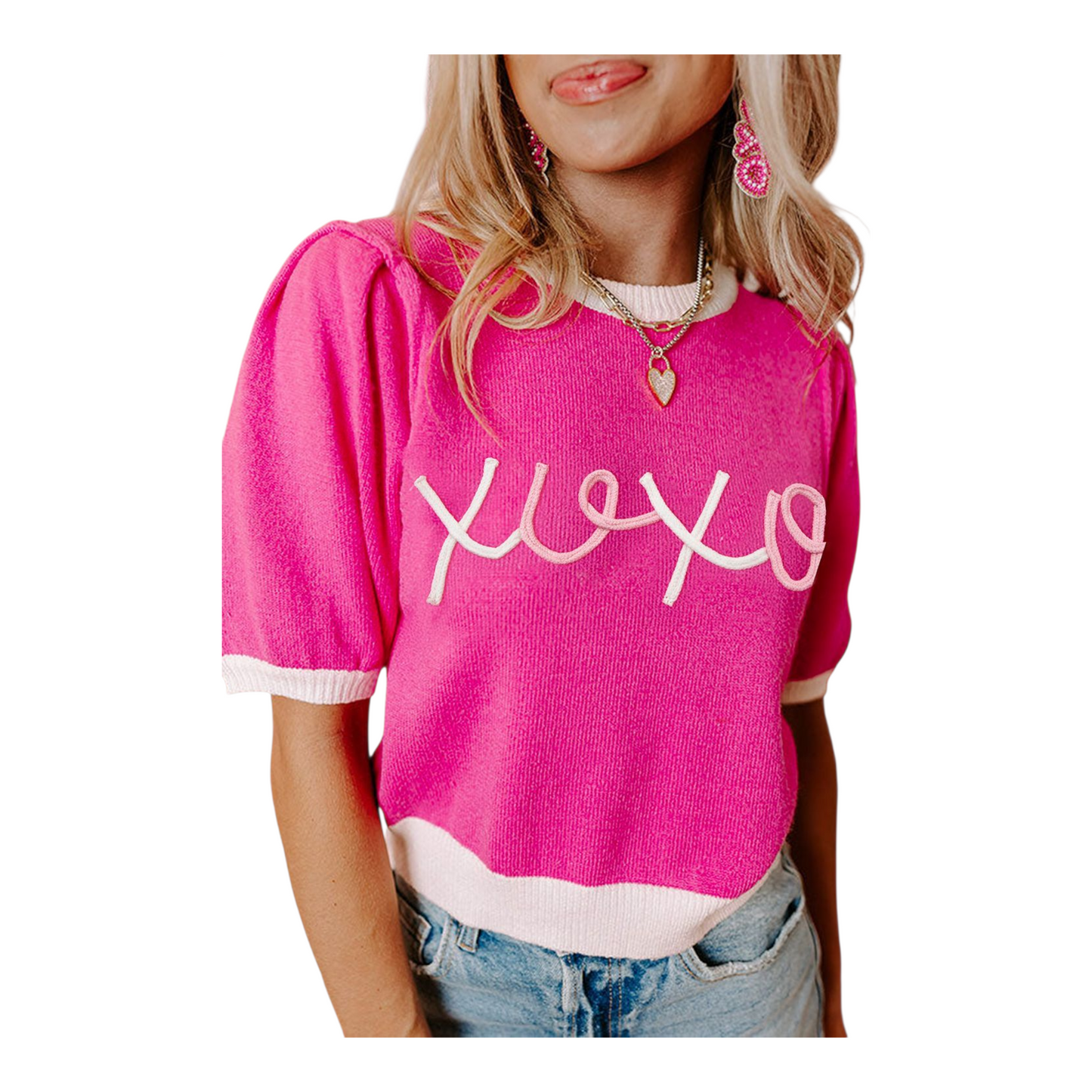Person wearing a pink sweater with 'xoxo' text on a white background