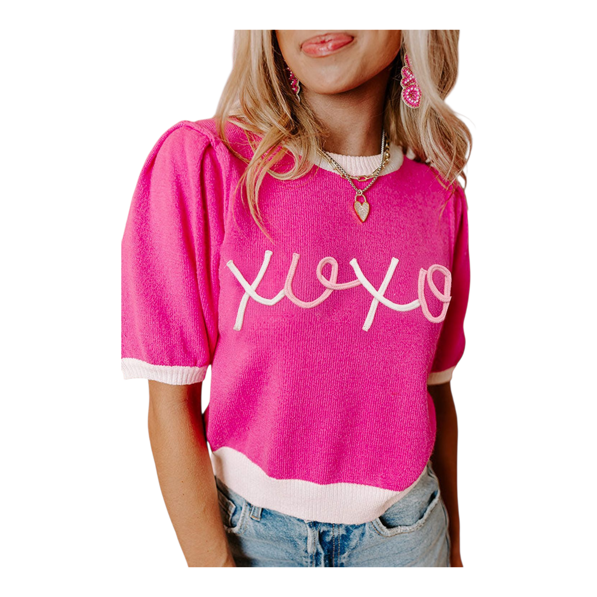 Person wearing a pink sweater with 'xoxo' text on a white background