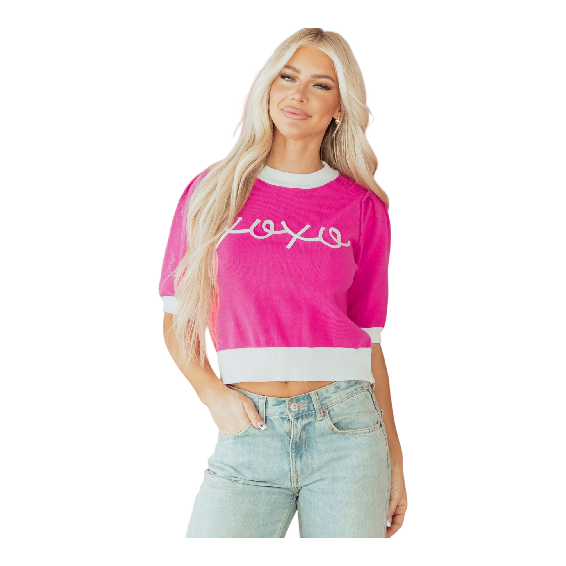 Woman wearing a pink crop top with text and light blue jeans on a white background